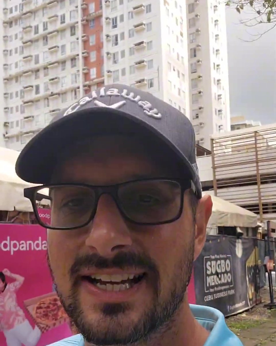Todd Michael Gori in a navy cap and glasses with city towers behind him