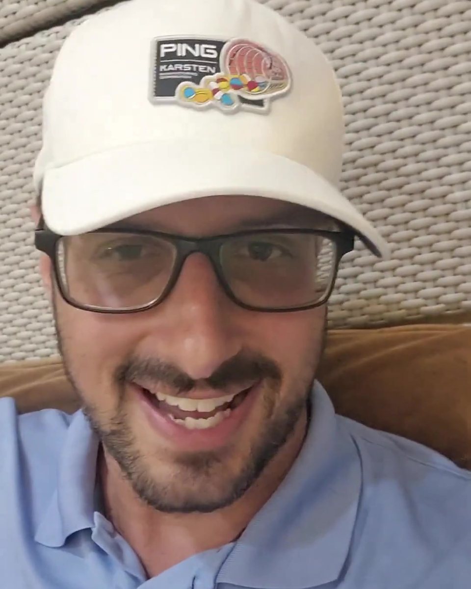 Todd Michael Gori in a white cap and glasses, smiling indoors
