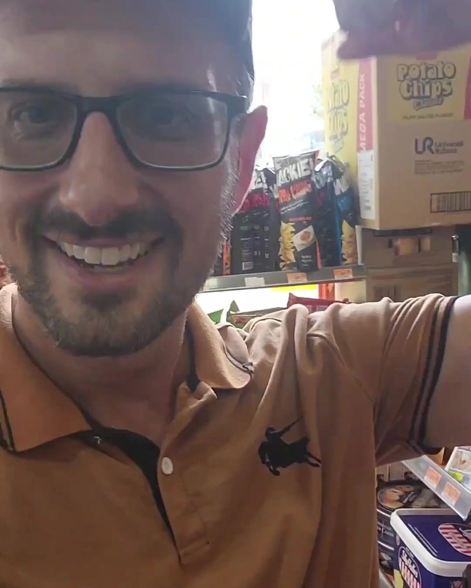 Todd Michael Gori in glasses and a brown polo smiling in a shop
