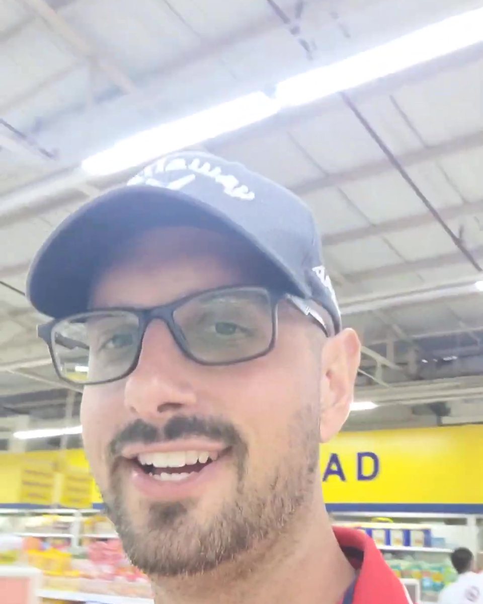 Todd Michael Gori in a navy cap and red polo in a supermarket