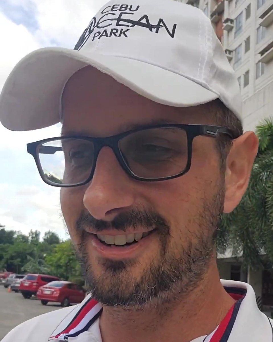 Todd Michael Gori in a white cap and glasses, smiling outdoors
